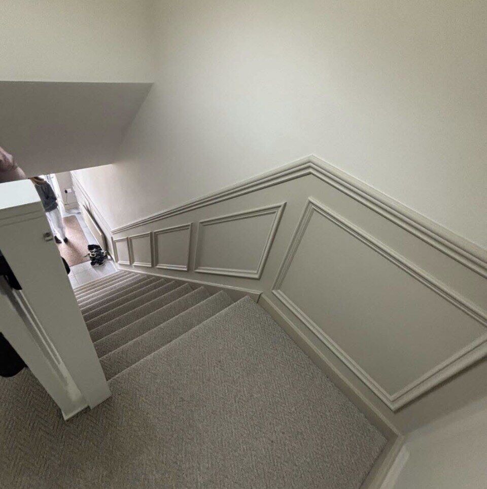 Hallway and stairs finished with panel moulding by Romenzo Construction